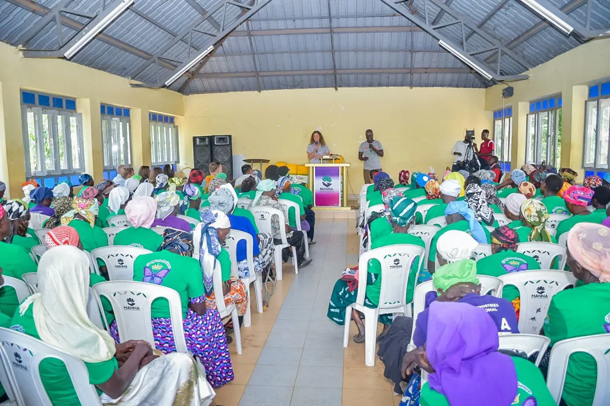 A large hall filled with widows served by Manna Ministries during a gathering