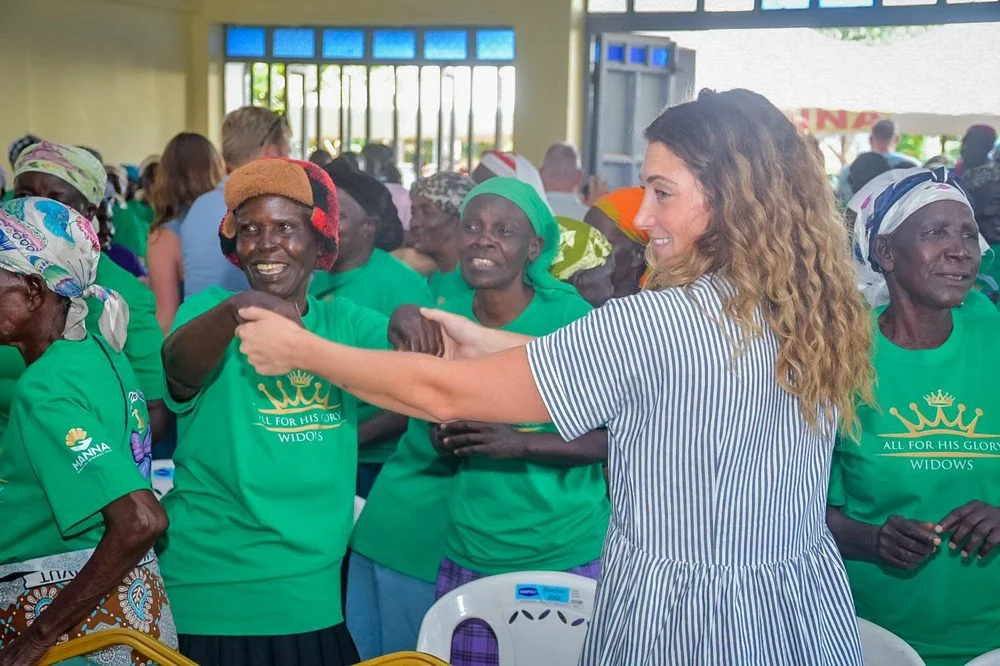 People smiling and celebrating together during a community gathering with Manna Ministries in Kenya