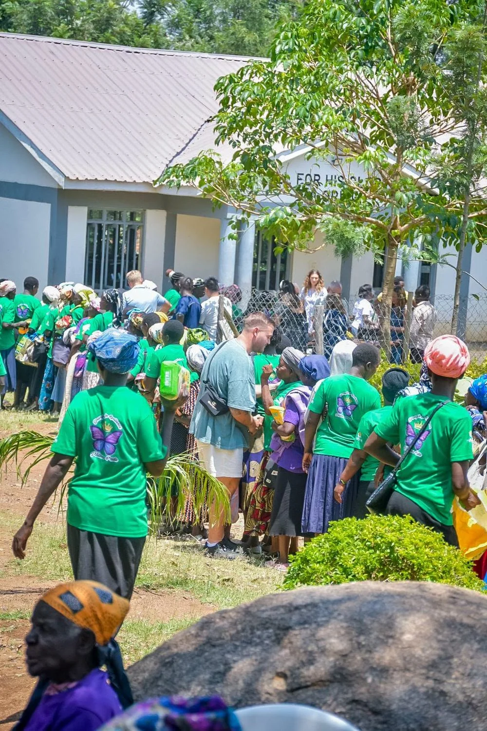 Community members gathering outside a building during a Manna Ministries visit in Kenya